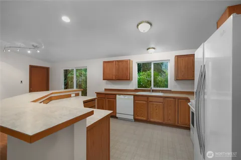 a large kitchen with kitchen island granite countertop a stove a sink and a refrigerator