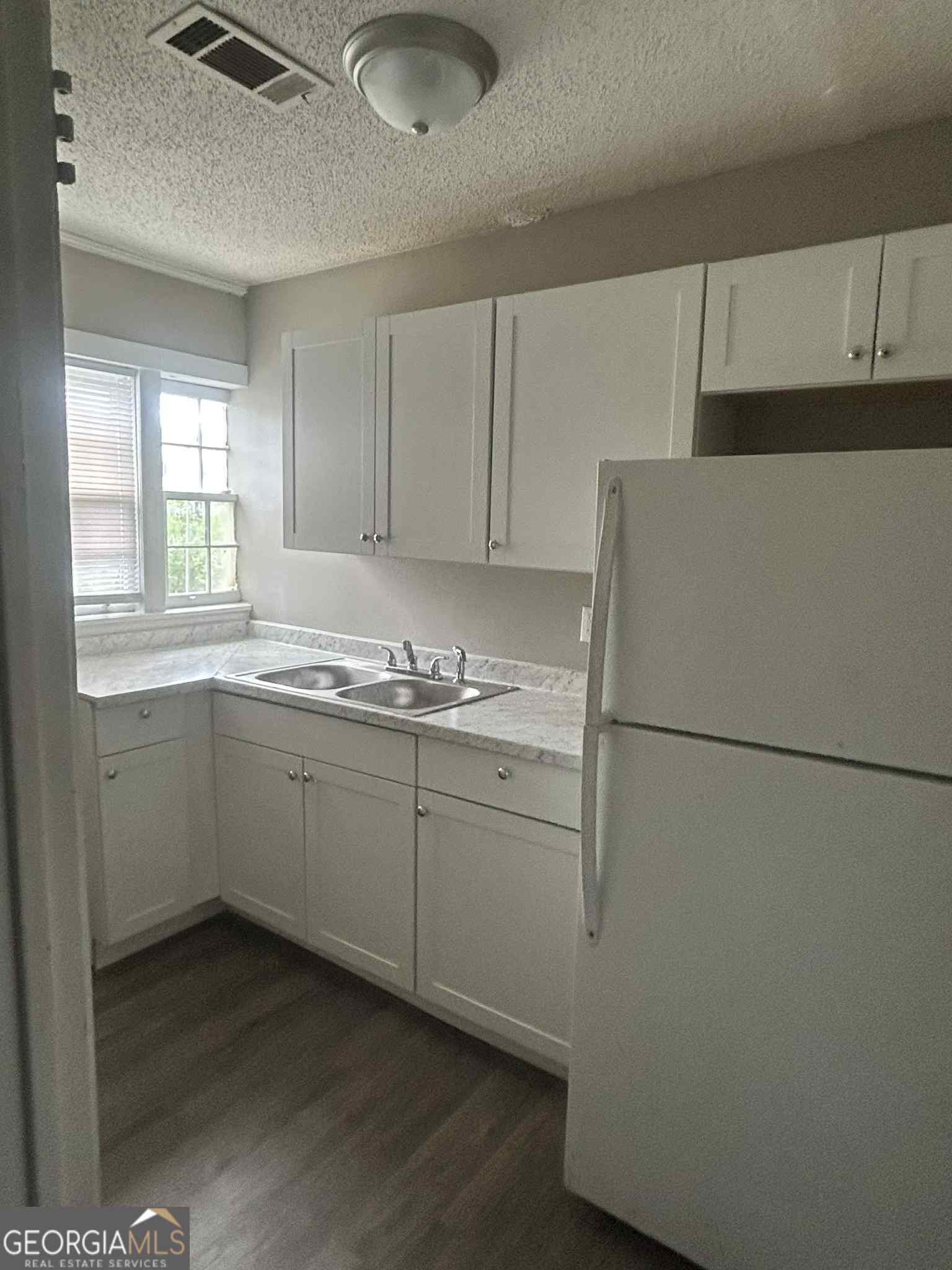 227 Straight Street, Unit B Macon, GA 31204 - Photo 3 of 5 a kitchen with a refrigerator sink stove and cabinets