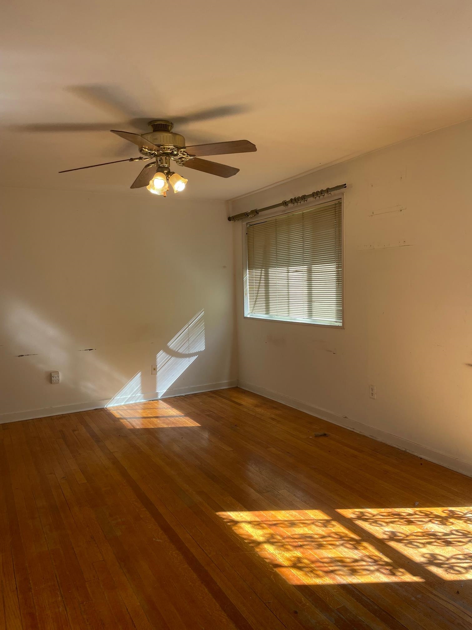 253 Montelo Road Memphis, TN 38120 - Photo 3 of 13 a view of an empty room with wooden floor and fan