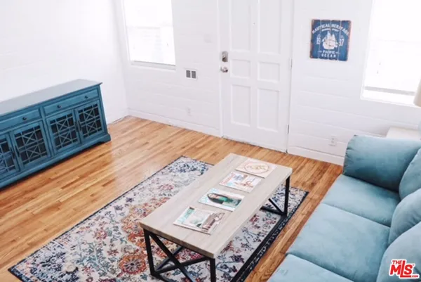 a living room with a bed and a wooden floor