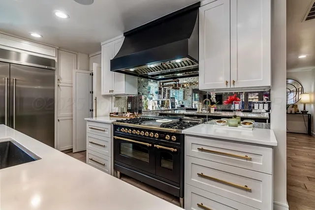 a kitchen with cabinets stainless steel appliances and wooden floor