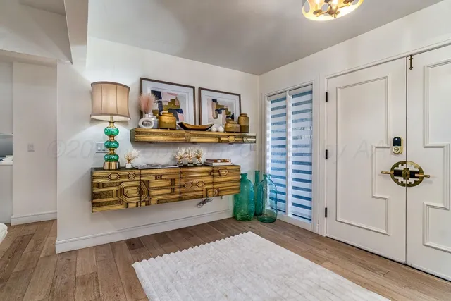 a living room with lots of white furniture and a flat screen tv