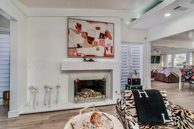 a living room with furniture a flat screen tv and kitchen view