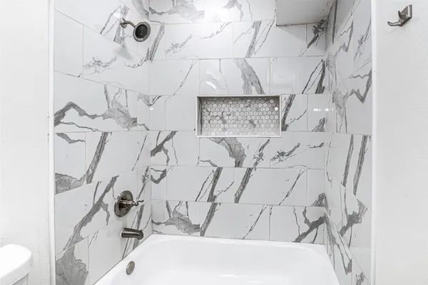 a bathroom with a bathtub and shower