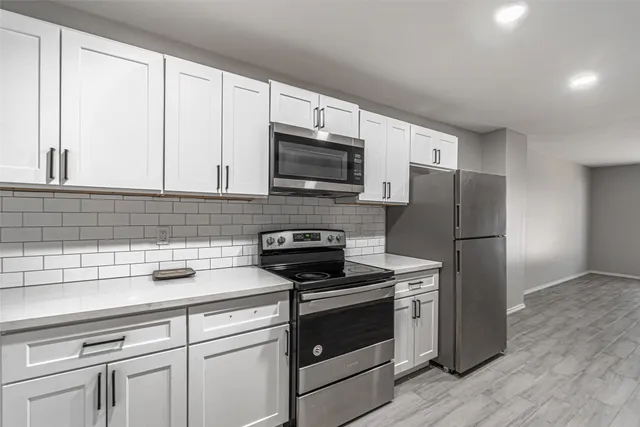a kitchen with a refrigerator stove and microwave