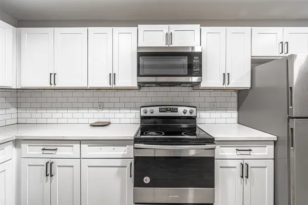 a kitchen with stainless steel appliances white cabinets and a stove