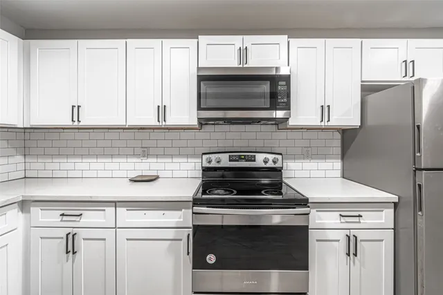 a kitchen with stainless steel appliances white cabinets and a stove