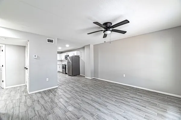a view of a livingroom with wooden floor and a ceiling fan