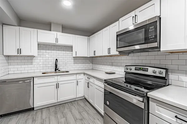 a kitchen with a sink stove and white cabinets