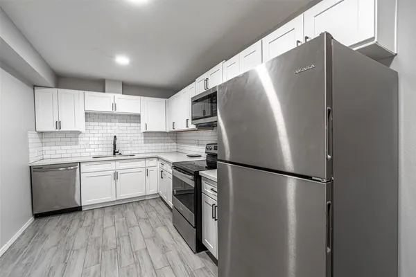 a kitchen with stainless steel appliances a refrigerator sink and microwave