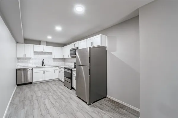 a kitchen with a refrigerator sink and wooden cabinets