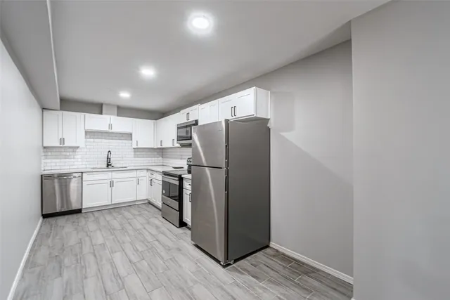 a kitchen with a refrigerator sink and wooden cabinets