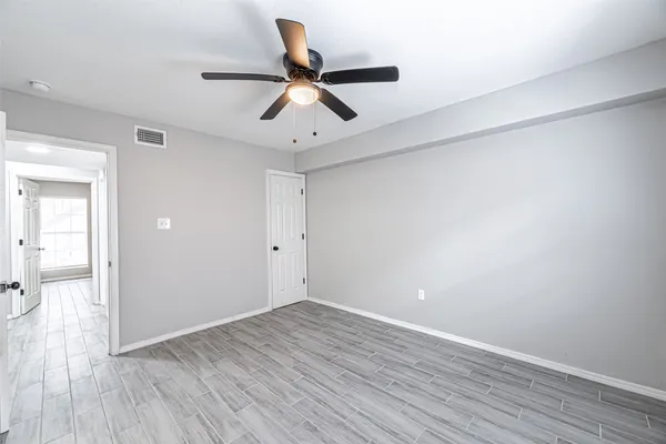 a view of a room with wooden floor and ceiling fan