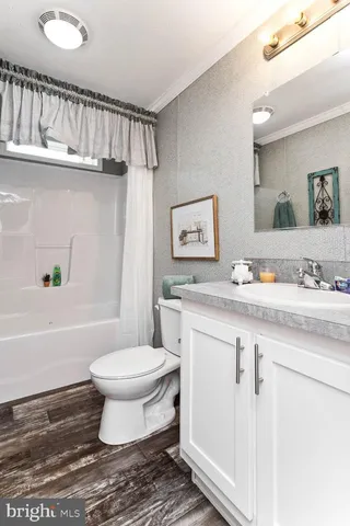 a bathroom with a granite countertop toilet sink and mirror