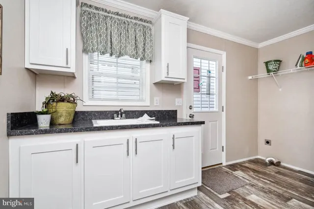 a kitchen with granite countertop white cabinets and a sink
