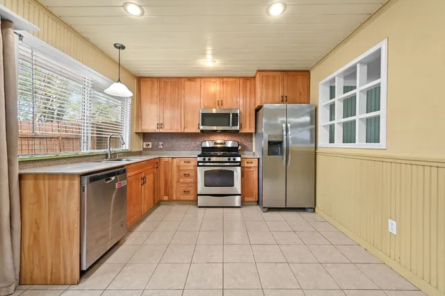 a kitchen with stainless steel appliances granite countertop a stove a sink and a refrigerator