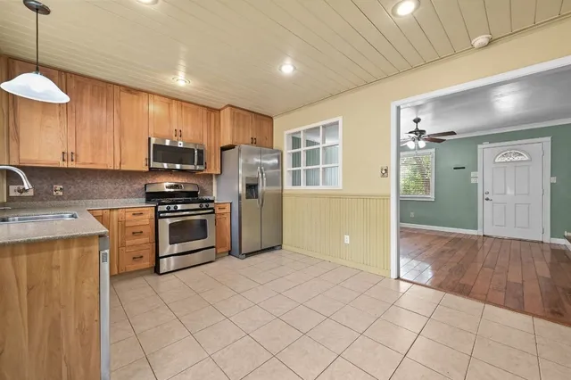 a kitchen with stainless steel appliances a refrigerator and a stove top oven
