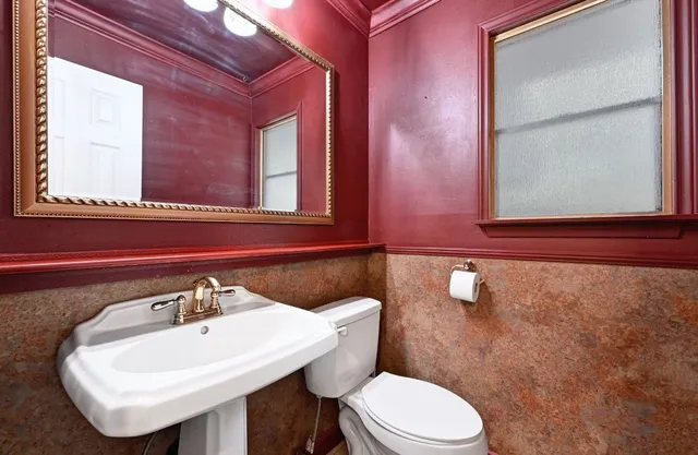 a bathroom with a toilet a sink and mirror