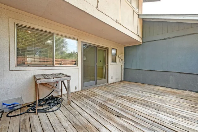 a view of a backyard of a house with wooden floor and iron fence