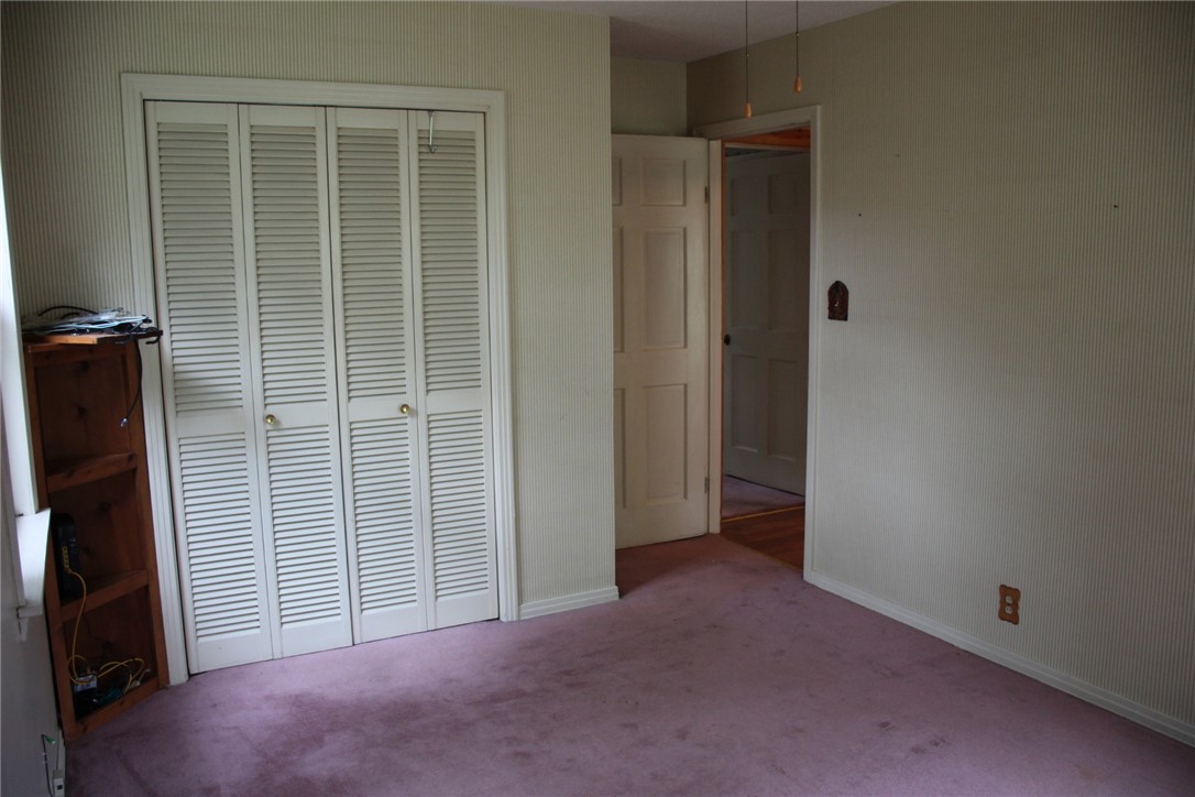 402 Canaan Road Marshall, AR 72650 - Photo 22 of 37 Interior room featuring a four-panel louvered closet door, light-toned walls, and a visible doorway