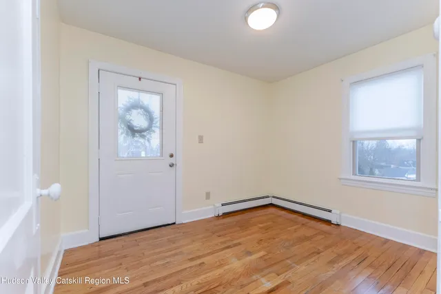 a view of an empty room with wooden floor and closet