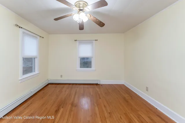 an empty room with a window and a ceiling fan