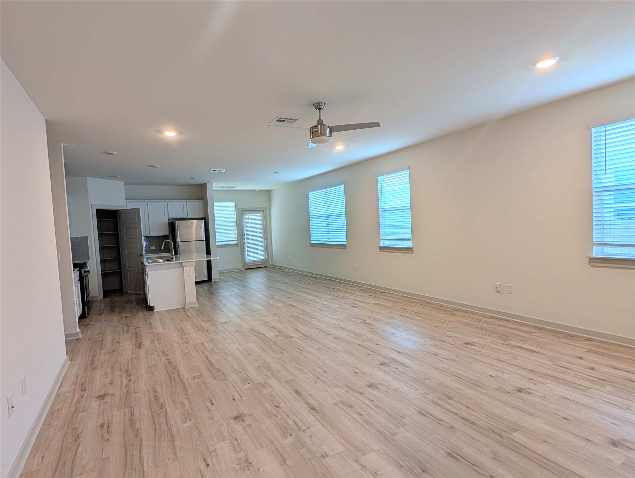 261 Century Plant Road Leander, TX 78641 - Photo 23 of 25 An open floorplan with durable laminate flooring seamlessly connects the kitchen and living areas.