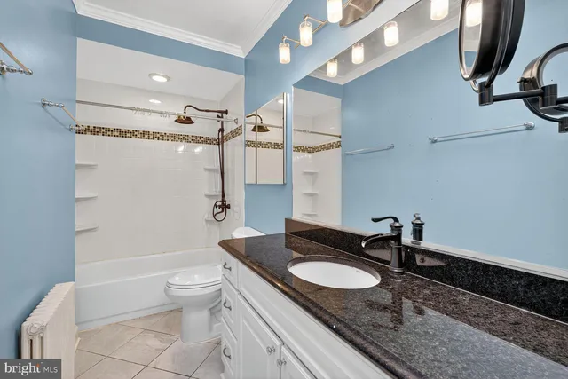 a bathroom with a granite countertop sink a toilet a mirror and shower