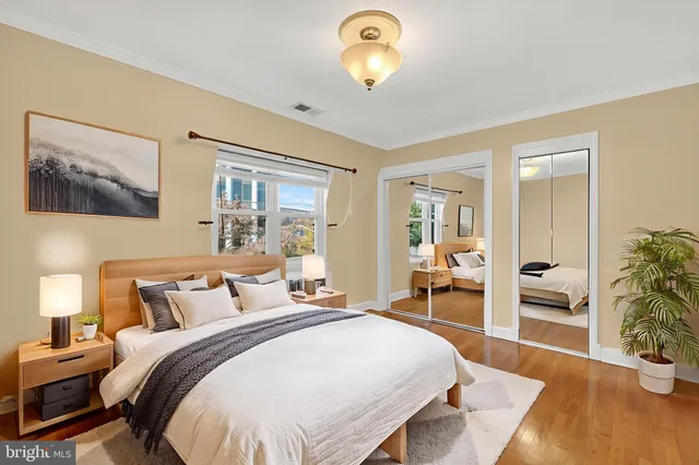 a spacious bedroom with a bed and wooden floor