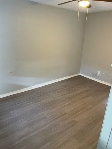 a view of an empty room with wooden floor