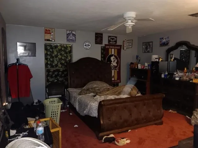 a bedroom with a bed a dresser and potted plants