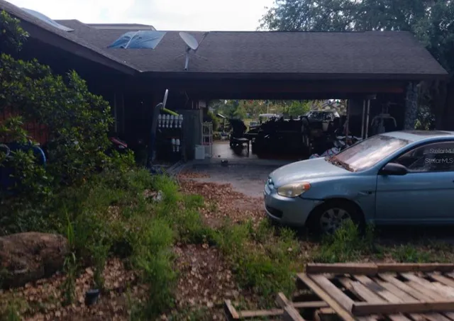 a view of patio with table and chairs potted plants and large tree