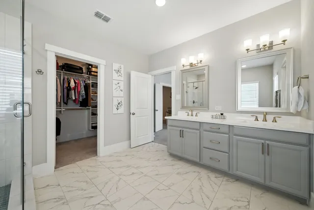 a spacious bathroom with a double vanity sink mirror and shower