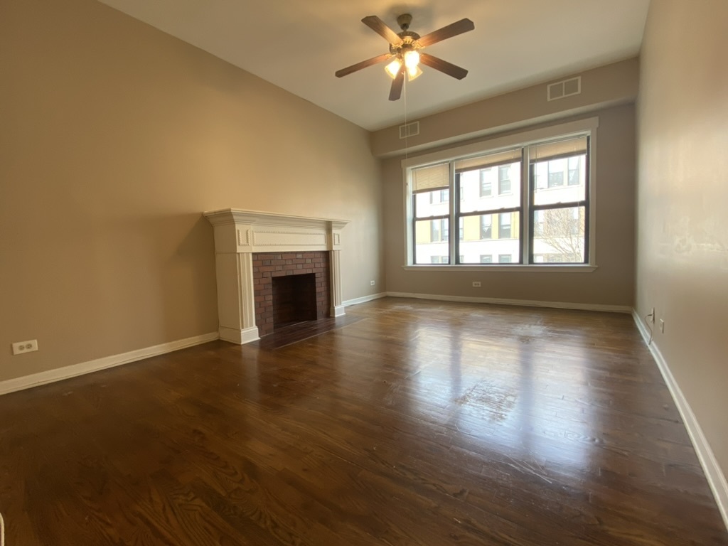 4409 North Hazel Street, Unit 2S Chicago, IL 60613 - Photo 2 of 7 a view of an empty room with wooden floor and a window