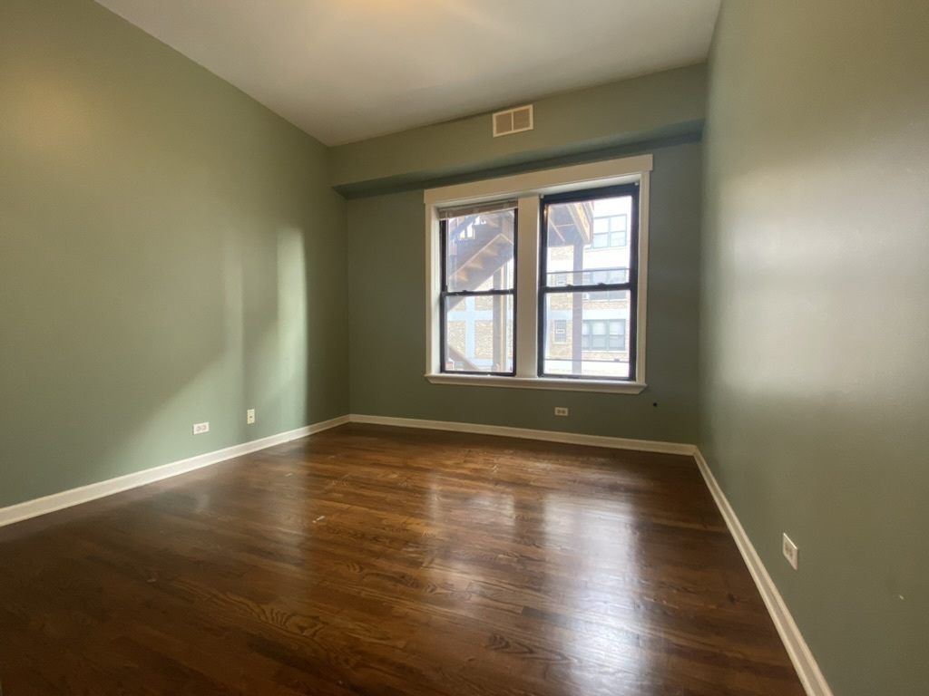 4409 North Hazel Street, Unit 2S Chicago, IL 60613 - Photo 3 of 7 a view of an empty room with wooden floor and a window
