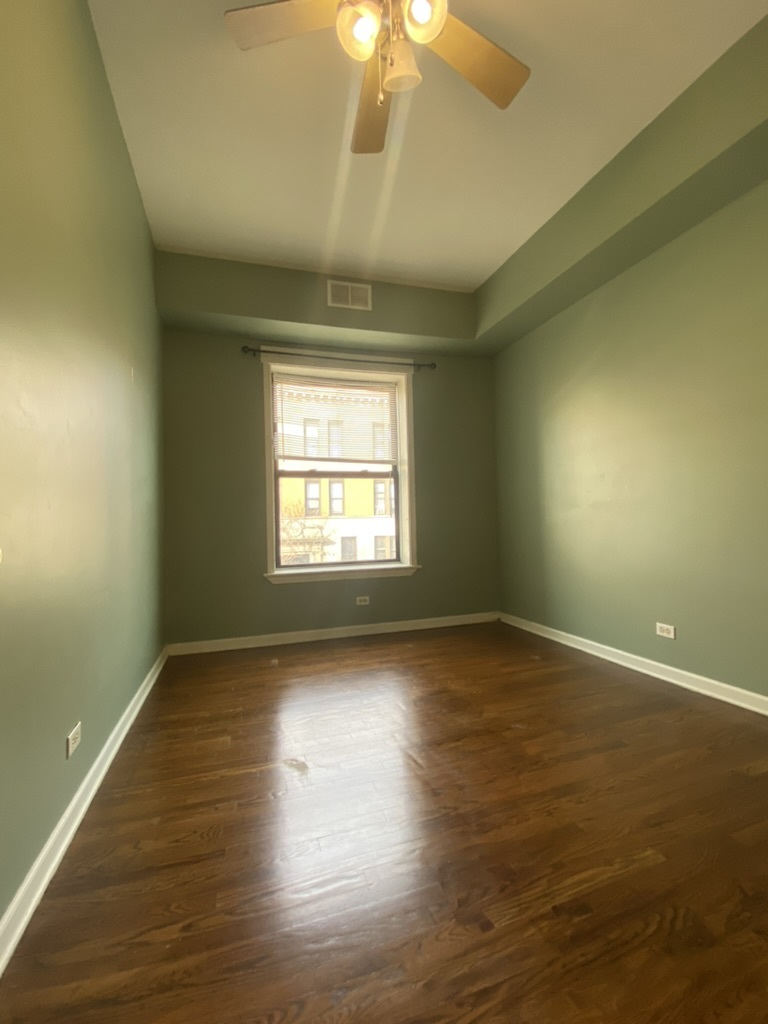 4409 North Hazel Street, Unit 2S Chicago, IL 60613 - Photo 4 of 7 an empty room with wooden floor and windows