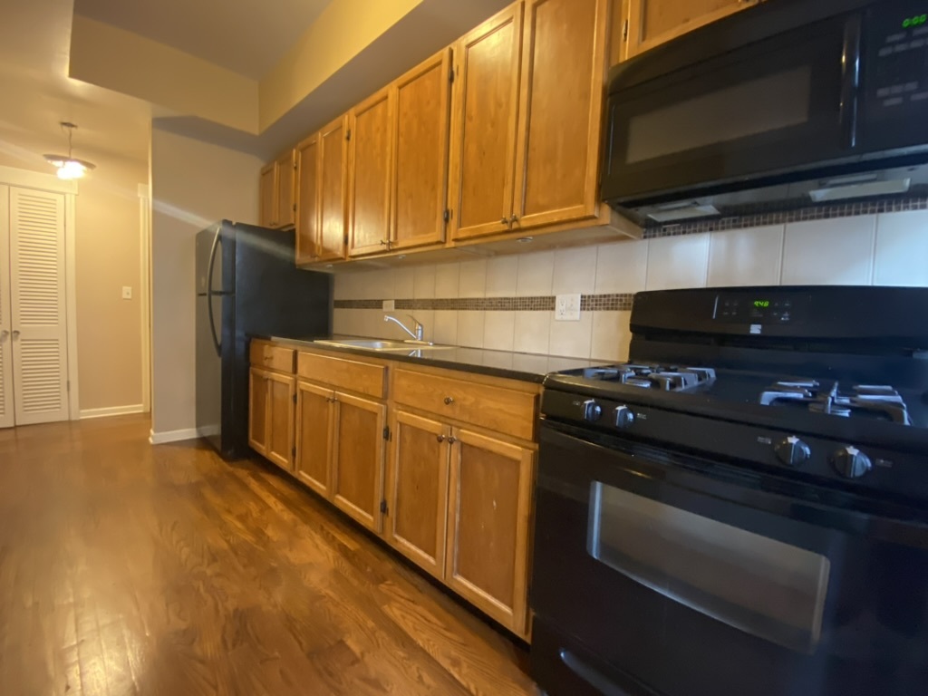 4409 North Hazel Street, Unit 2S Chicago, IL 60613 - Photo 6 of 7 a kitchen with stainless steel appliances granite countertop a stove and a microwave