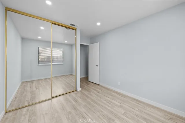 an empty room with wooden floor and mirror