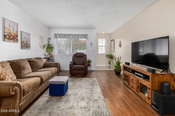 a living room with furniture a chandelier and a wooden floor