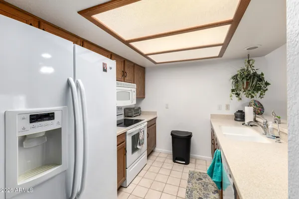 a kitchen with kitchen island granite countertop sink and refrigerator