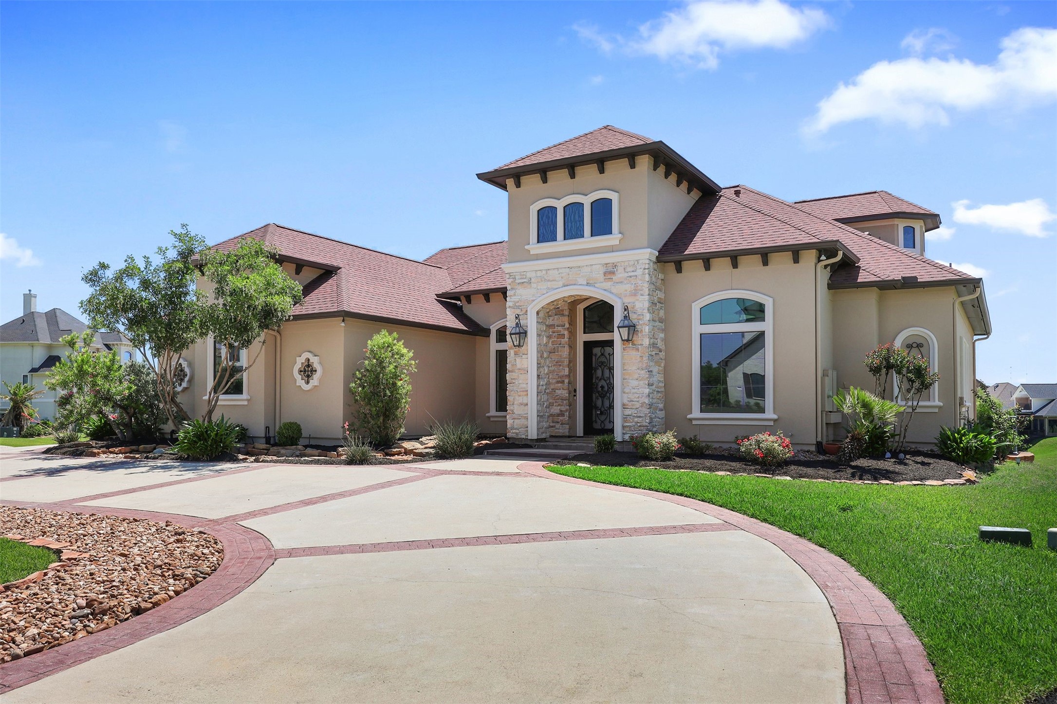 10896 Decatur Street Willis, TX 77318 - Photo 10 of 50 Discover the perfect blend of elegance and comfort in this stunning two-story home, featuring a charming stone and stucco exterior, arched windows, and a red-tiled roof, all enhanced by lush landscaping and a welcoming driveway.