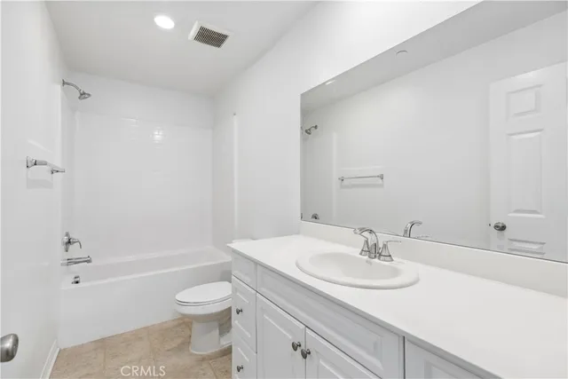 a bathroom with a granite countertop sink a toilet and shower
