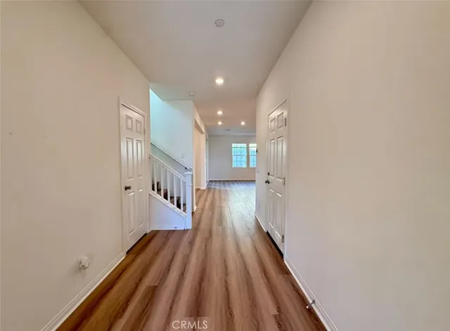 a view of a hallway with wooden floor and staircase