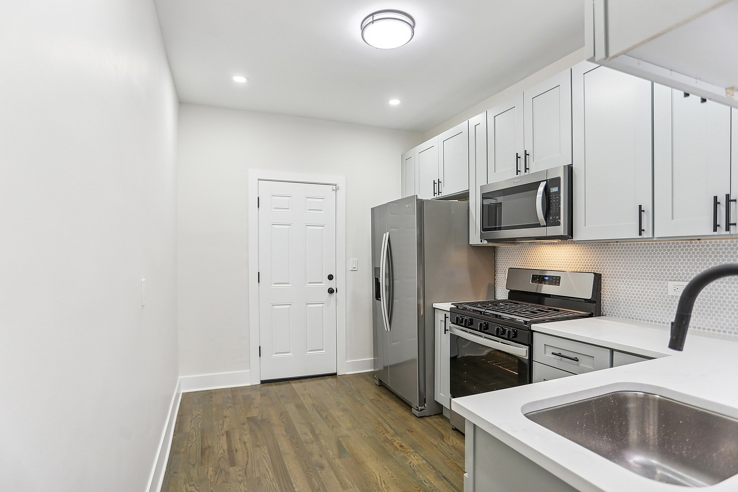 4832 West Harrison Street Chicago, IL 60644 - Photo 16 of 21 a kitchen with stainless steel appliances white cabinets and a sink