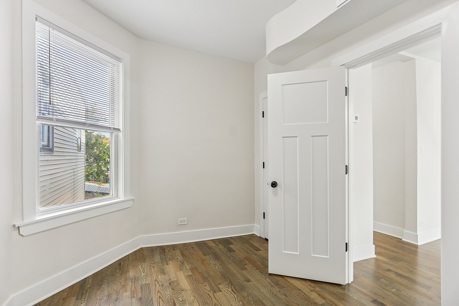 4832 West Harrison Street Chicago, IL 60644 - Photo 8 of 21 an empty room with wooden floor and windows