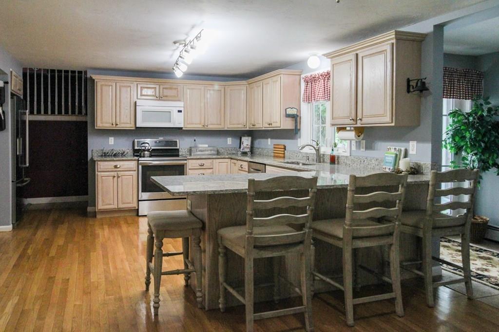 871 Northfield Road Lunenburg, MA 01462 - Photo 16 of 39 a kitchen with a table chairs refrigerator and cabinets