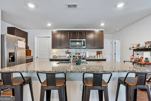 a kitchen with stainless steel appliances granite countertop a sink stove and cabinets