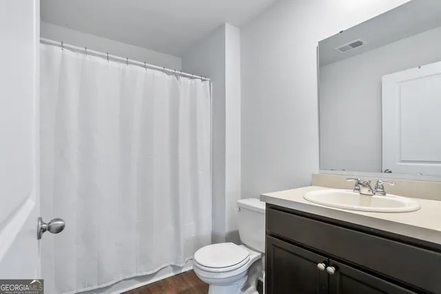 a white toilet sitting next to a shower curtain