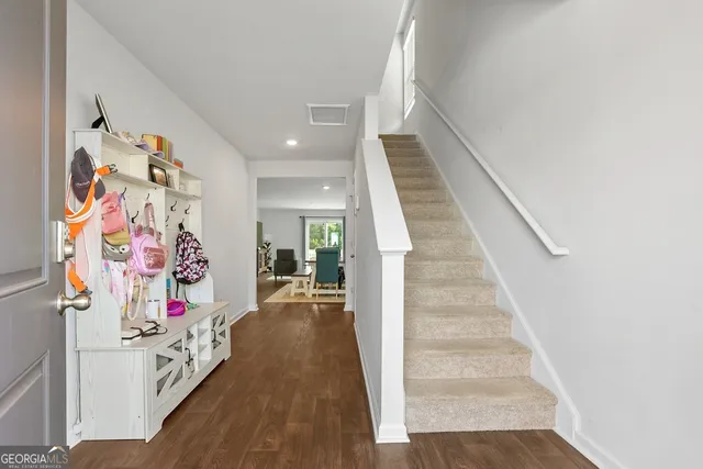 a living room with furniture a wooden floor and a bookshelf