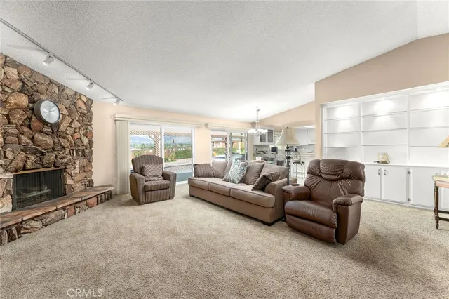 a kitchen with stainless steel appliances kitchen island granite countertop a refrigerator a stove a sink dishwasher and white cabinets with wooden floor